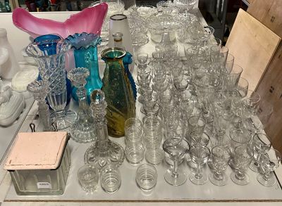 many glasses and vases on a table in a store