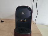 a coffee maker sitting on a wooden table in a room