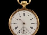 a gold pocket watch with roman numerals on the face