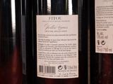 three bottles of wine are lined up on a shelf