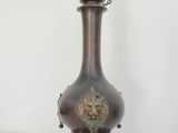 a large bronze vase with a lion head on it