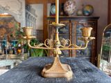 a brass candelab with three candles on top of it