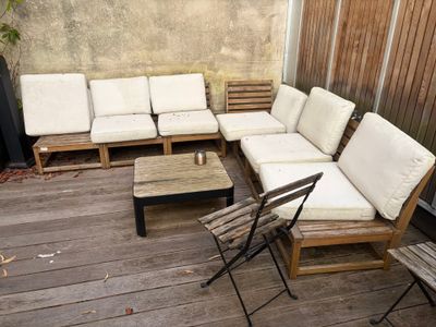 a couch and chairs on a wooden deck with a table