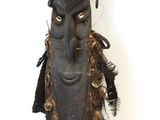 a small wooden statue of a man with a mohawk on it ' s head