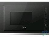 the microwave is black and silver in color and has a built in grill