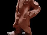 une sculpture en argile représentant un homme debout sur un rocher
