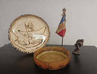 a bowl and a plate on a table next to a statue