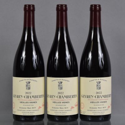 trois bouteilles de vin sont alignées sur une table