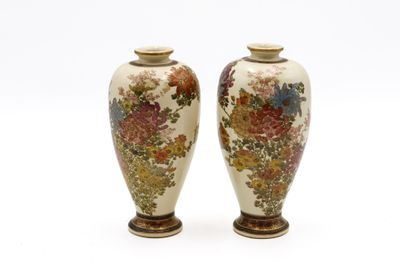 deux vases ornés de fleurs, posés sur un fond blanc
