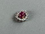 a close up of a ruby and diamond ring on a table