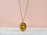un collier composé d'une pièce d'or sur laquelle est gravé le visage d'une femme