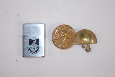 un briquet à côté d'un autre briquet sur lequel est apposée une médaille