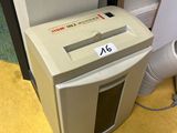 une déchiqueteuse posée par terre à côté d'une porte