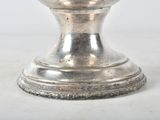 a silver candle holder with a candle on it