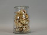 dried flowers in a glass jar on a white surface