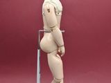 a wooden mannequin standing on a stand on a red background