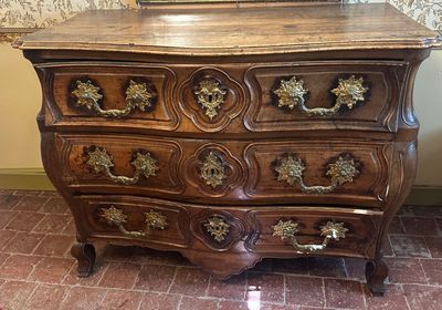 une commode en bois surmontée d'un miroir