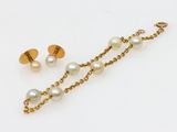 un gros plan sur une paire de boucles d'oreilles en perles et en or