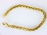 un bracelet en or avec un motif de tresse sur fond blanc