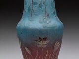 un vase bleu orné d'une fleur, posé sur une table