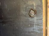 a black door with a bolt on it in a room