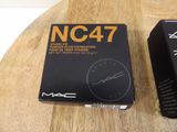 two boxes of mac cosmetics on a wooden table with a clock