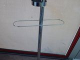 a metal stand with a cup on it in front of a door