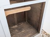 an old oven with a wooden handle in the corner