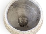 a cement pot with a hole in it on a white surface