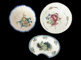 trois assiettes ornées de motifs floraux et de feuilles sur fond noir