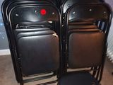 many black chairs in a room with a red button on the back
