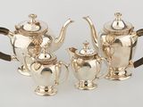 three pieces of silver tea and coffee set on a table