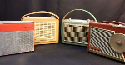 three old fashioned radio ' s are lined up on a black background
