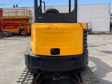 the back end of a small yellow construction vehicle parked in a parking lot