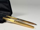 two pens in a black case sitting on top of a white table
