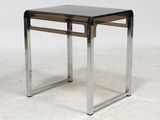 a black and chrome side table with a glass top