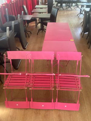 une table et des chaises roses au milieu d'une pièce