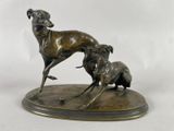 statue en bronze représentant un chien et un chat sur un socle