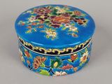 une petite boîte bleue ornée d'un motif floral