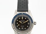 une image représentant une montre noire et bleue posée sur une surface blanche