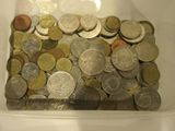 un récipient en plastique rempli de pièces de monnaie posé sur une table