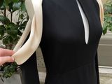 a mannequin on a mannequin stand with a black dress on it