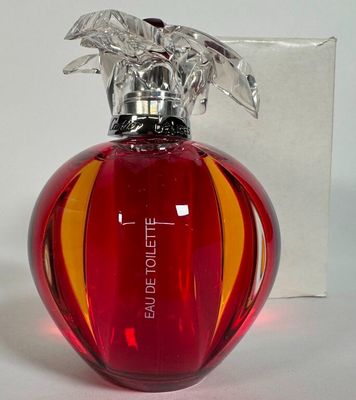 un flacon de parfum rouge avec un bouchon argenté et une boîte en arrière-plan