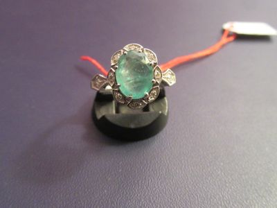 une bague ornée d'une pierre verte, montée sur un cordon rouge