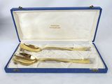 a pair of gold plated spoons in a blue case