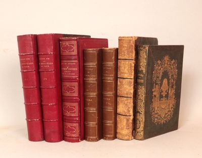 plusieurs vieux livres sont alignés sur une surface blanche