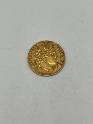 gros plan d'une pièce d'or sur une surface blanche