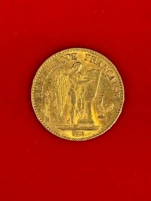 a close up of a gold coin on a red surface