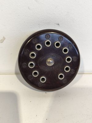 un gros plan d'une pomme de douche sur un mur blanc