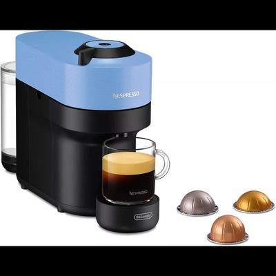 a close up of a cup of coffee next to a coffee maker